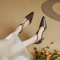 Brown and black women's pointed toe high heels made from cowhide leather.