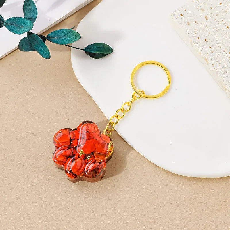 Hand-finished natural crystal cat's paw keychain pendant on a metal ring, showing detailed carving and polished stone surface.