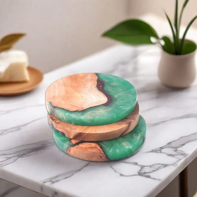 Set of four solid-colour wooden coasters in irregular round and square shapes on a wooden table.
