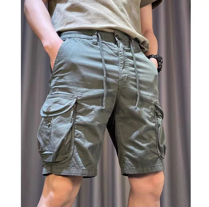 Loose straight-leg casual overalls with multiple cargo pockets in khaki, showing elastic waist and cropped length.