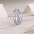Moissanite wedding ring with S925 silver platinum plated band on flat surface showing stone and certificate
