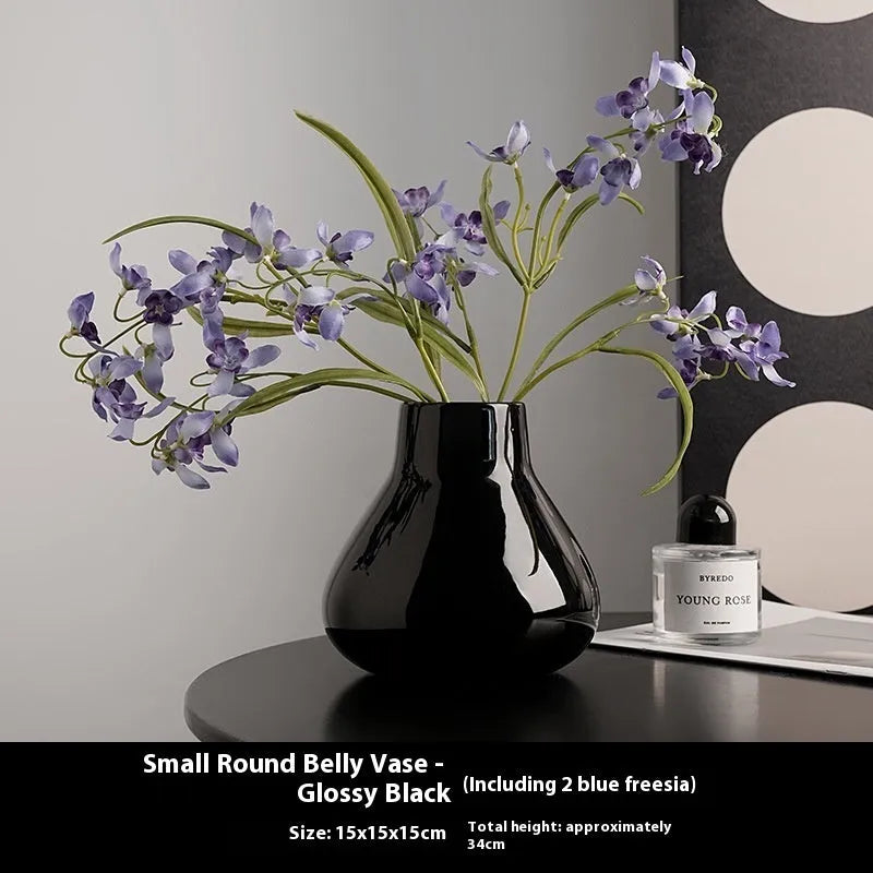 Modern ceramic vase with two white artificial orchid stems in minimalist home setting
