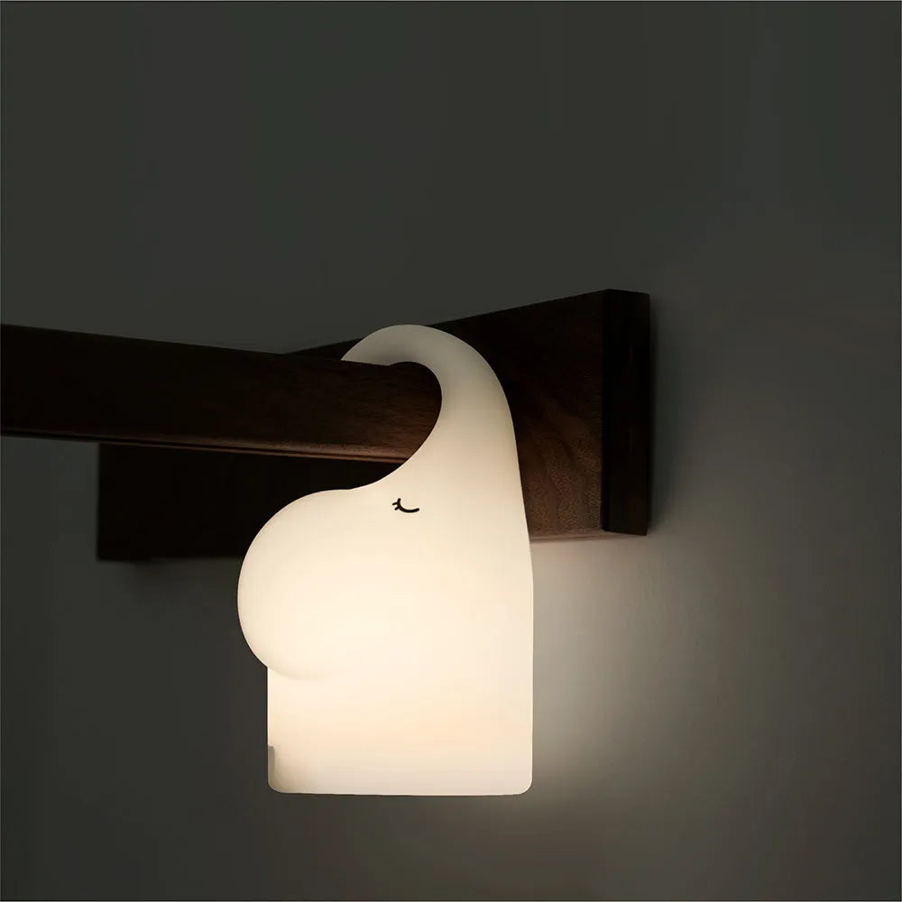 DOMI Elephant shaped silicone night light on a table showing its compact size and soft glow.