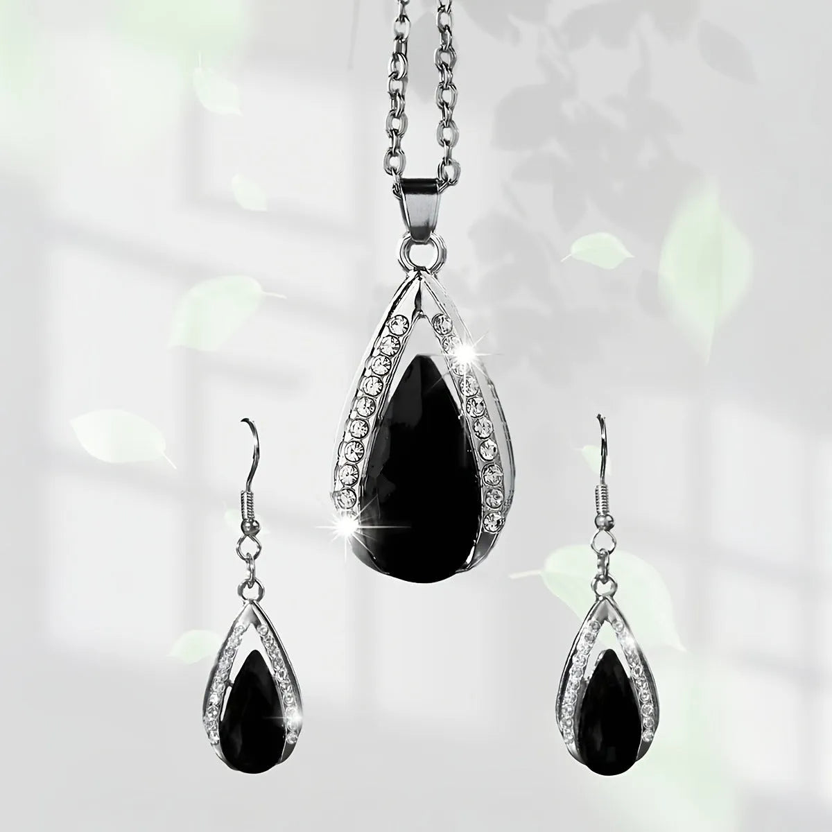 Black and red teardrop glass pendant necklace and matching alloy earrings set on display.