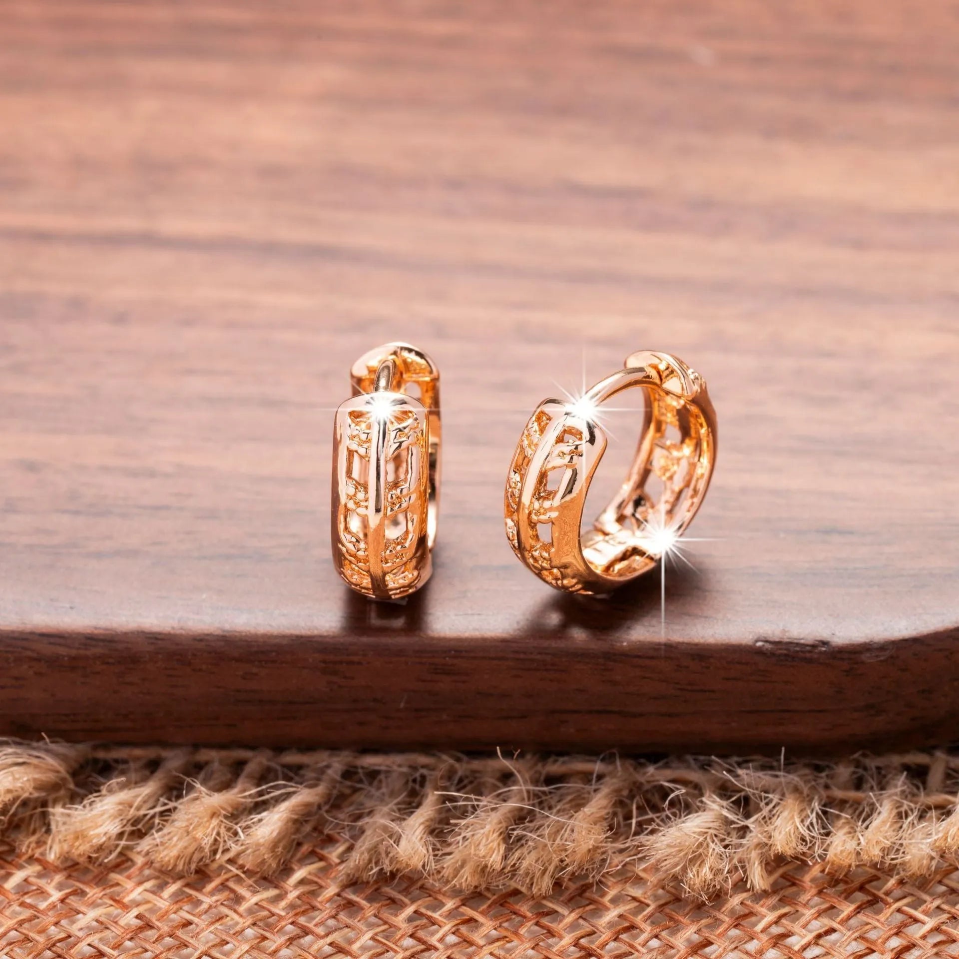 Small rose gold copper earrings with hollowed-out leaf and heart shapes.