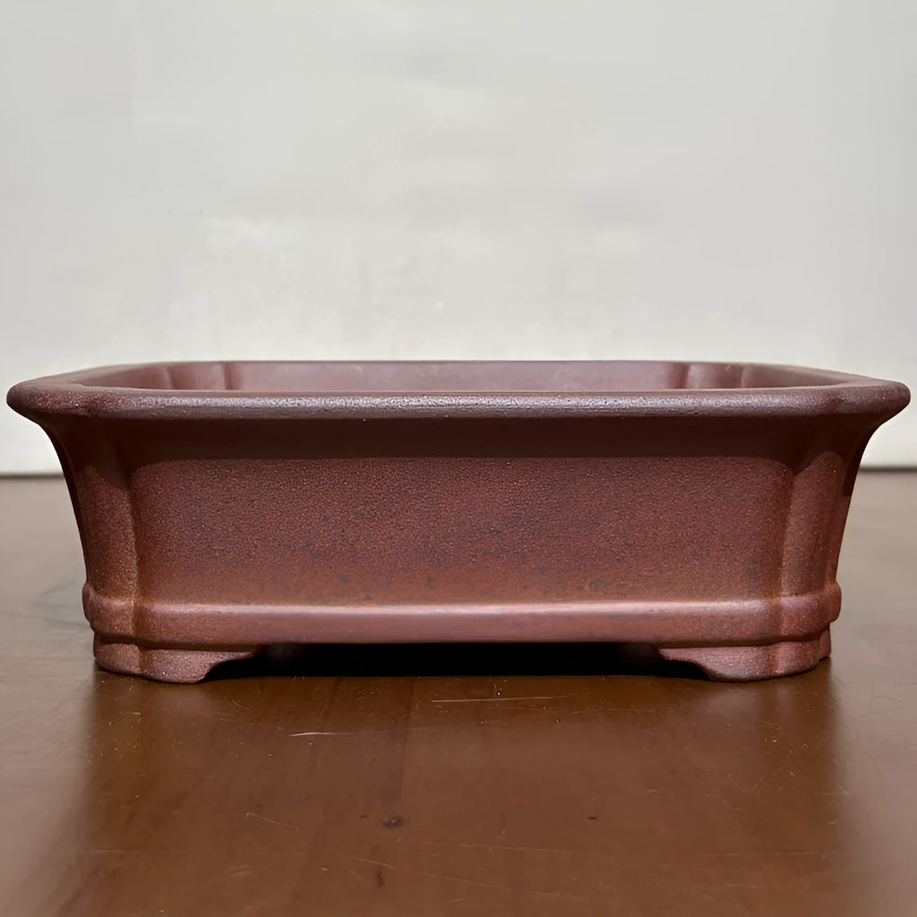 Reddish brown hand-glazed stoneware rectangular bonsai flower pot on a flat surface