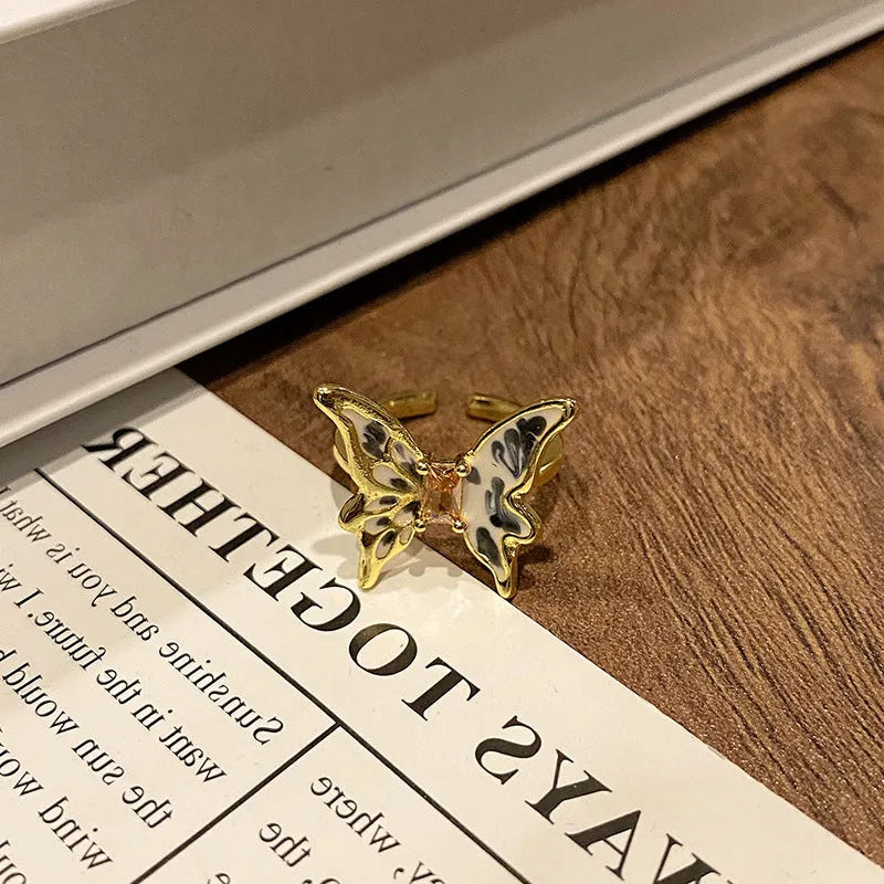 Creative butterfly design women's ring in copper with oil drip finish, showing an open loop style.