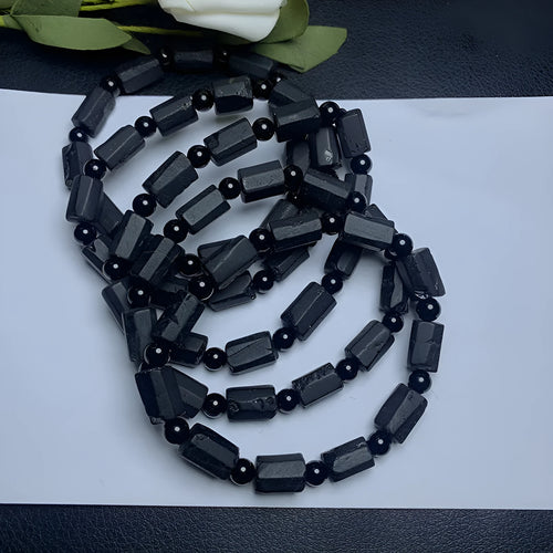 Black tourmaline rough stone bracelet on a wrist, showing natural texture and 10mm size