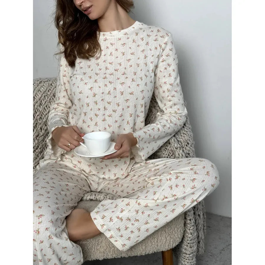 White women's floral print bell sleeve top and wide leg pants suit laid flat.