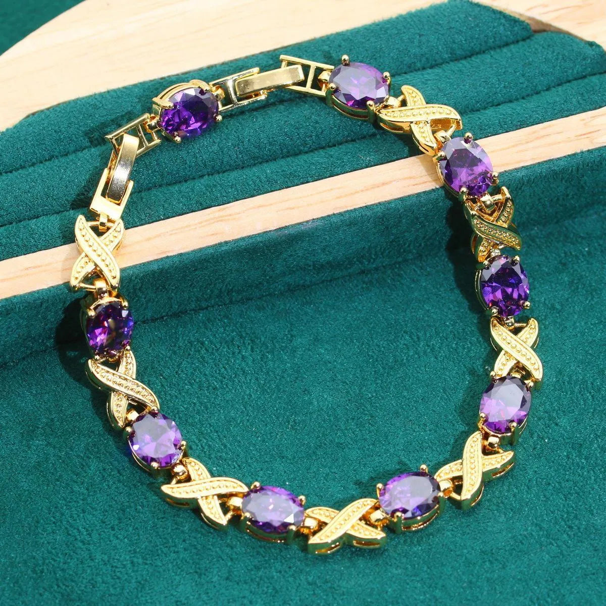 18k gold plated zircon jewellery set with necklace, earrings, ring, and bracelet on blue background