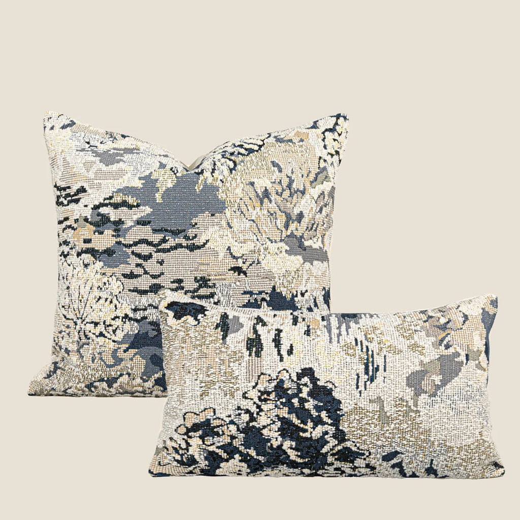 Blue floral antique pattern wool blend cushion cover and feather velvet pillow on a sofa.
