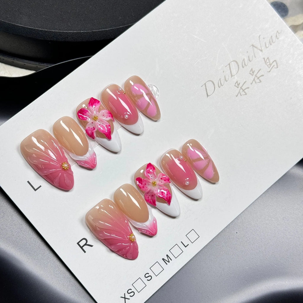 Set of white plastic almond-shaped nail tips with 3D raised lily and ice flower French manicure design.