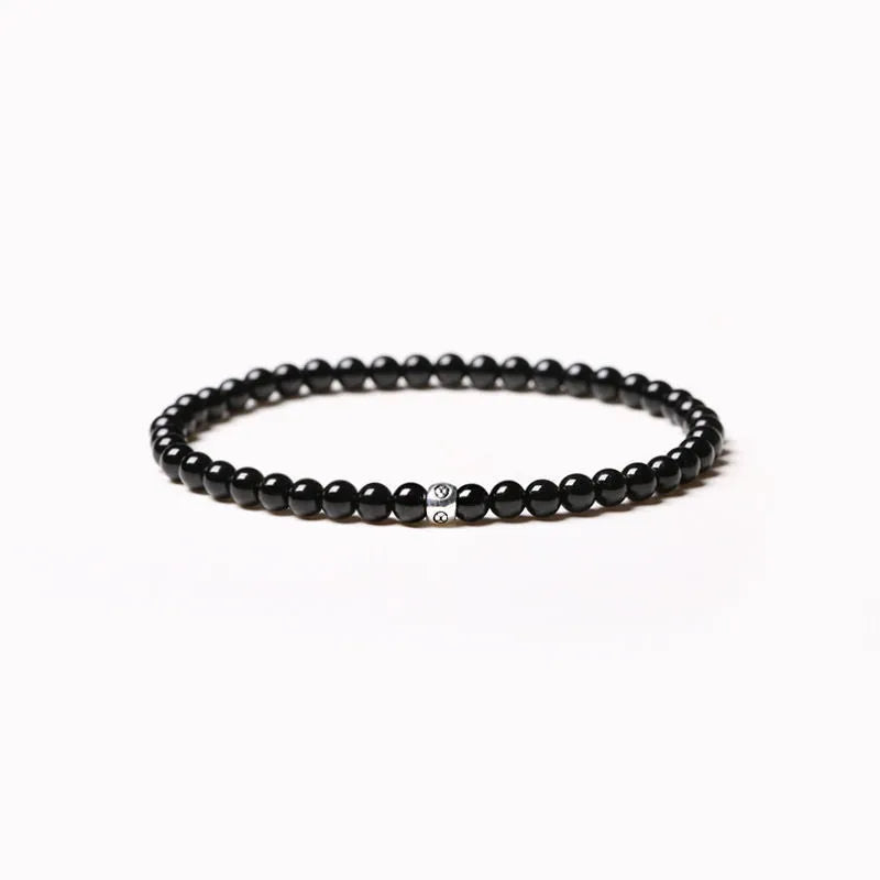 Geometric unisex bracelet with 4mm black agate, blue san, and obsidian beads on a wrist.