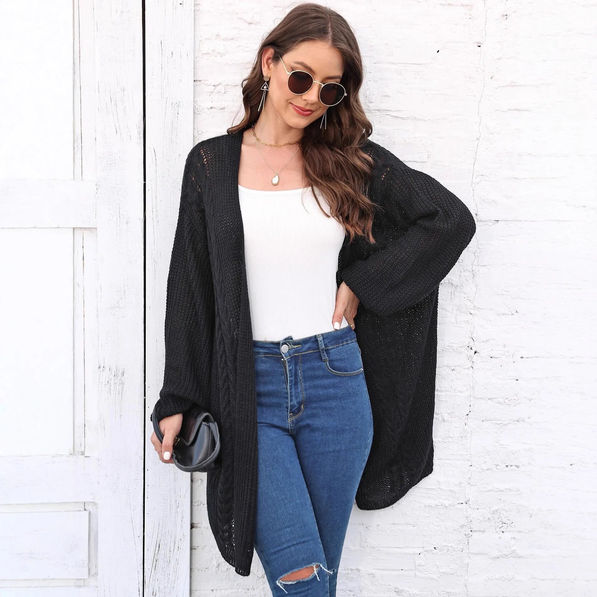 Women's loose acrylic sweater coat in a solid colour, shown in a casual style.