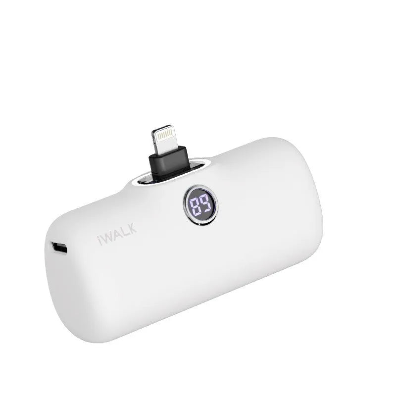 Compact white lipstick-shaped power bank with digital battery percentage display on a wooden table.