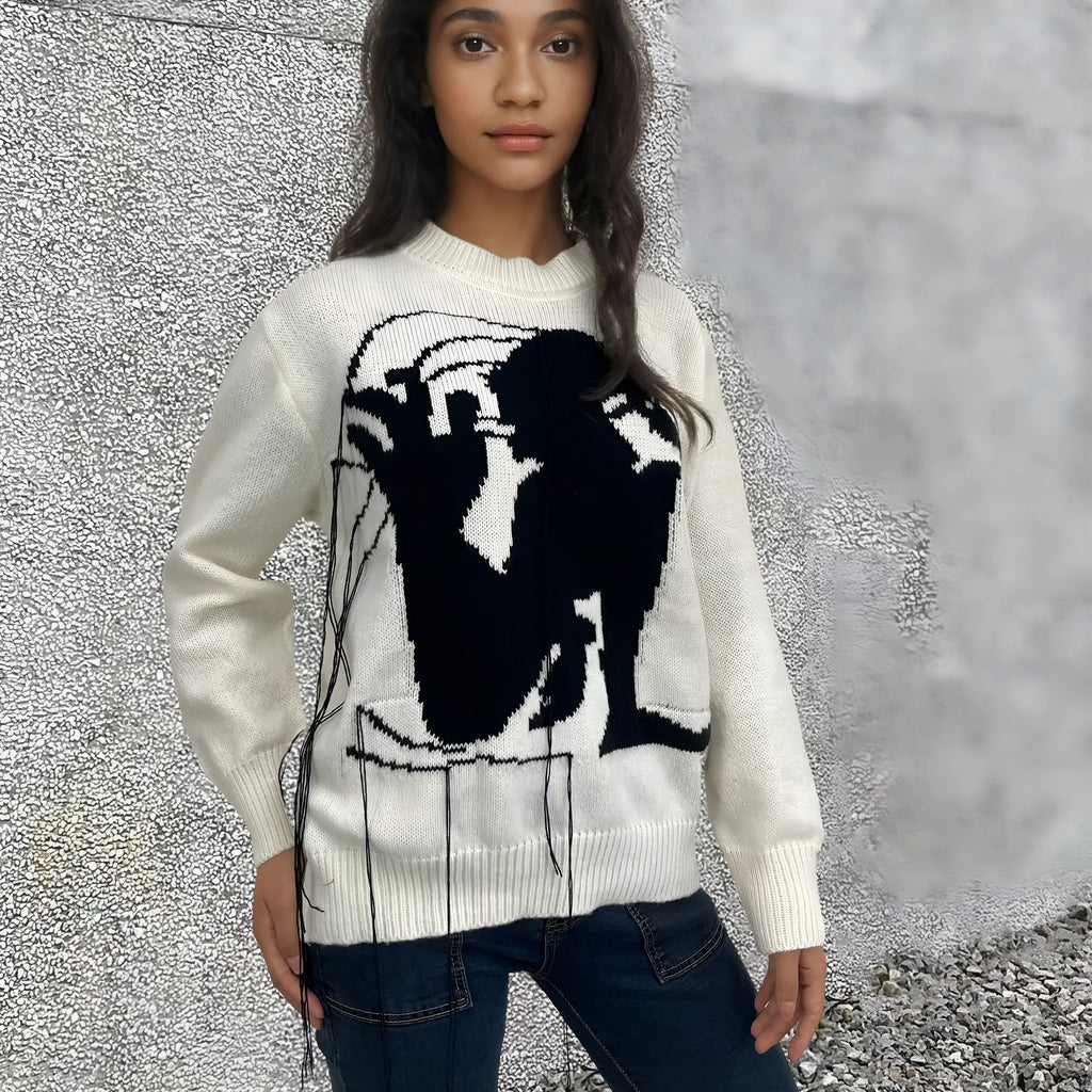 Grey women's alpaca wool sweater with abstract pattern and tassel detailing on a hanger.