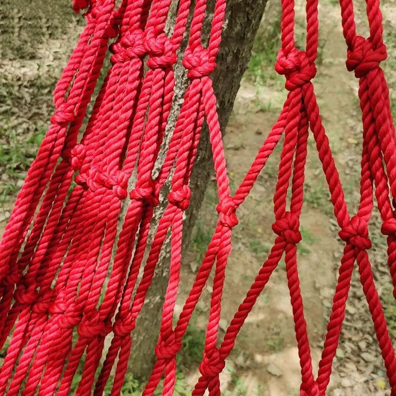 Outdoor bold style nylon rope mesh hammock shown in a garden setting