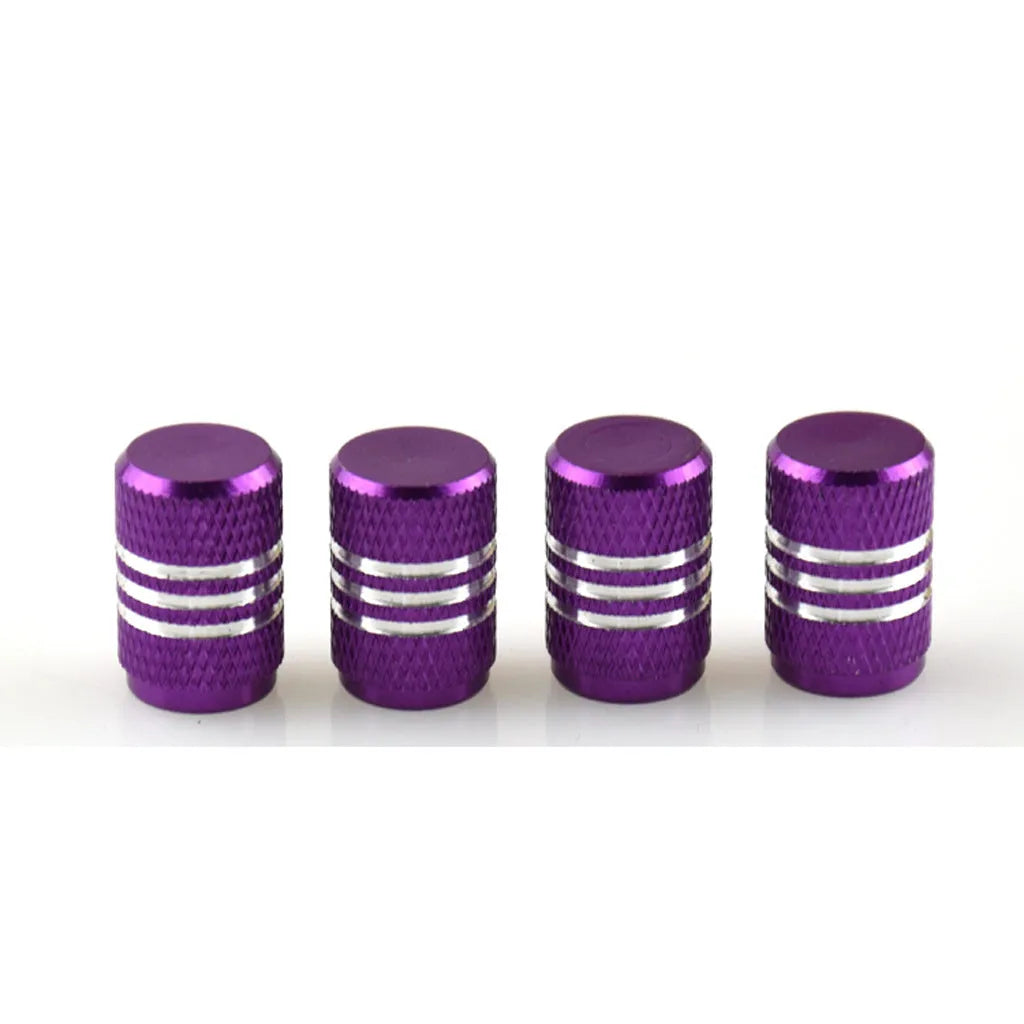 Assortment of aluminium alloy car tyre valve caps in ten different colours on a grey background.