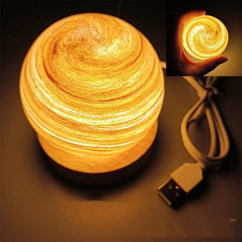 Modern planet-shaped USB night light with dimming on a desk.