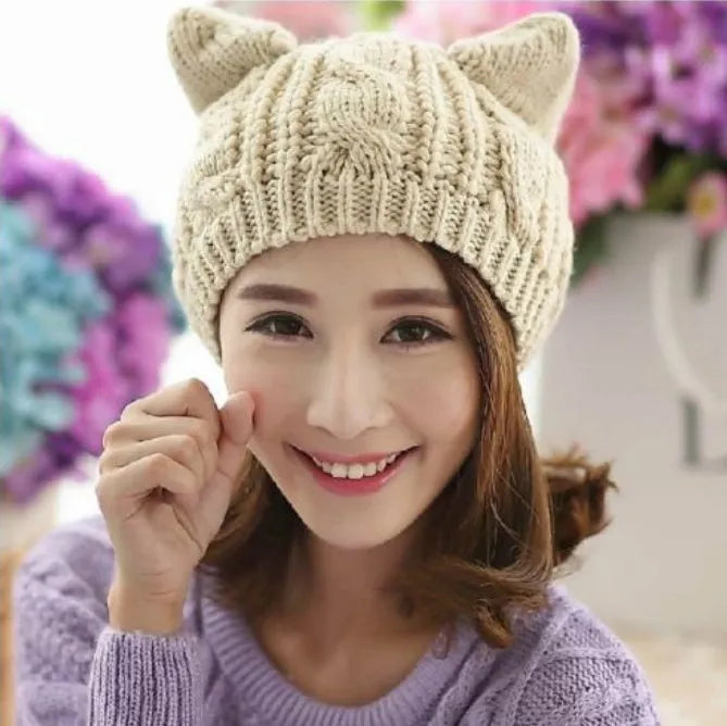 Hand knitted red wool beanie with 3D cat ears on a white background