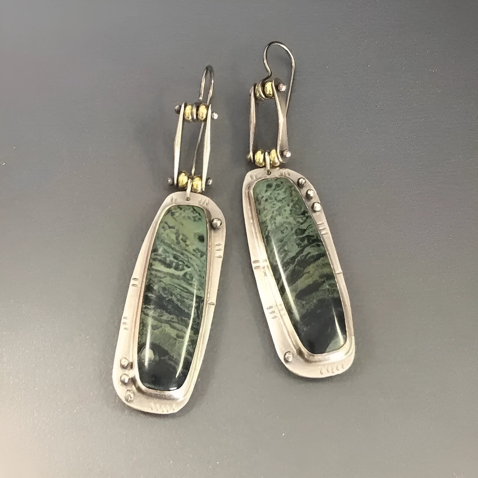 Geometric drop earrings with a white and grey marble pattern on a silver-toned alloy setting.