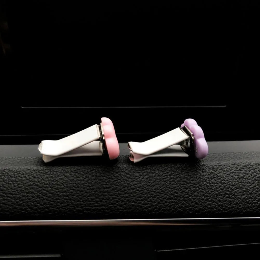 Resin cartoon car fragrance clip in pastel colours on a car air vent.