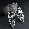 Silver geometric lotus vine earrings with rhinestone accents on white background