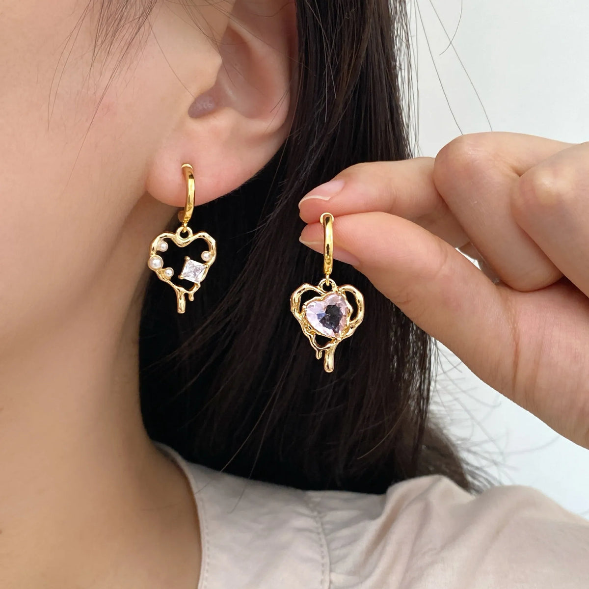 Asymmetric heart earrings with inlaid zircon on copper, available as ear clips or ear studs, one pair