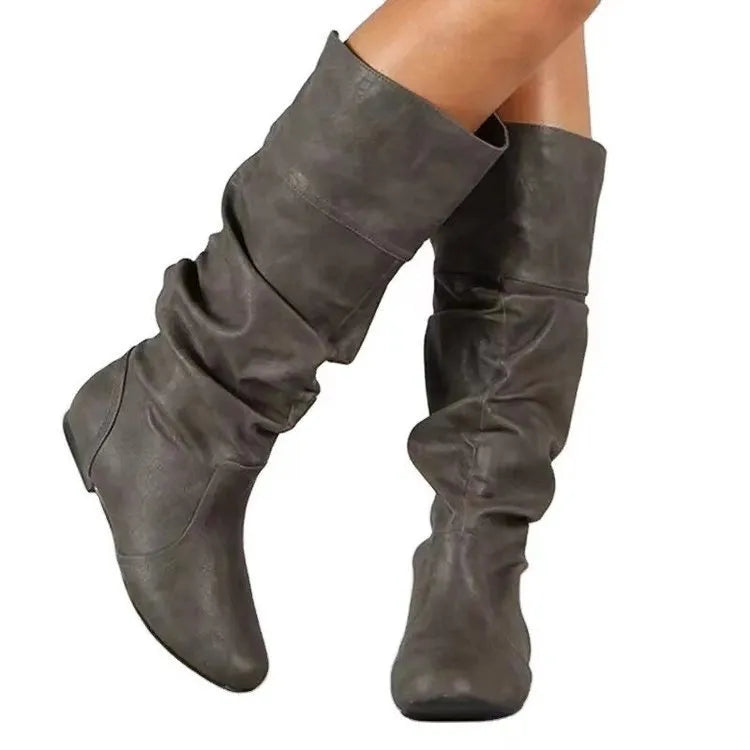 Women's black slip-on knee-high flat boots with a round toe and rubber sole.