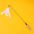 Close-up of a feather and bell replacement head for a spring cat teasing stick toy.