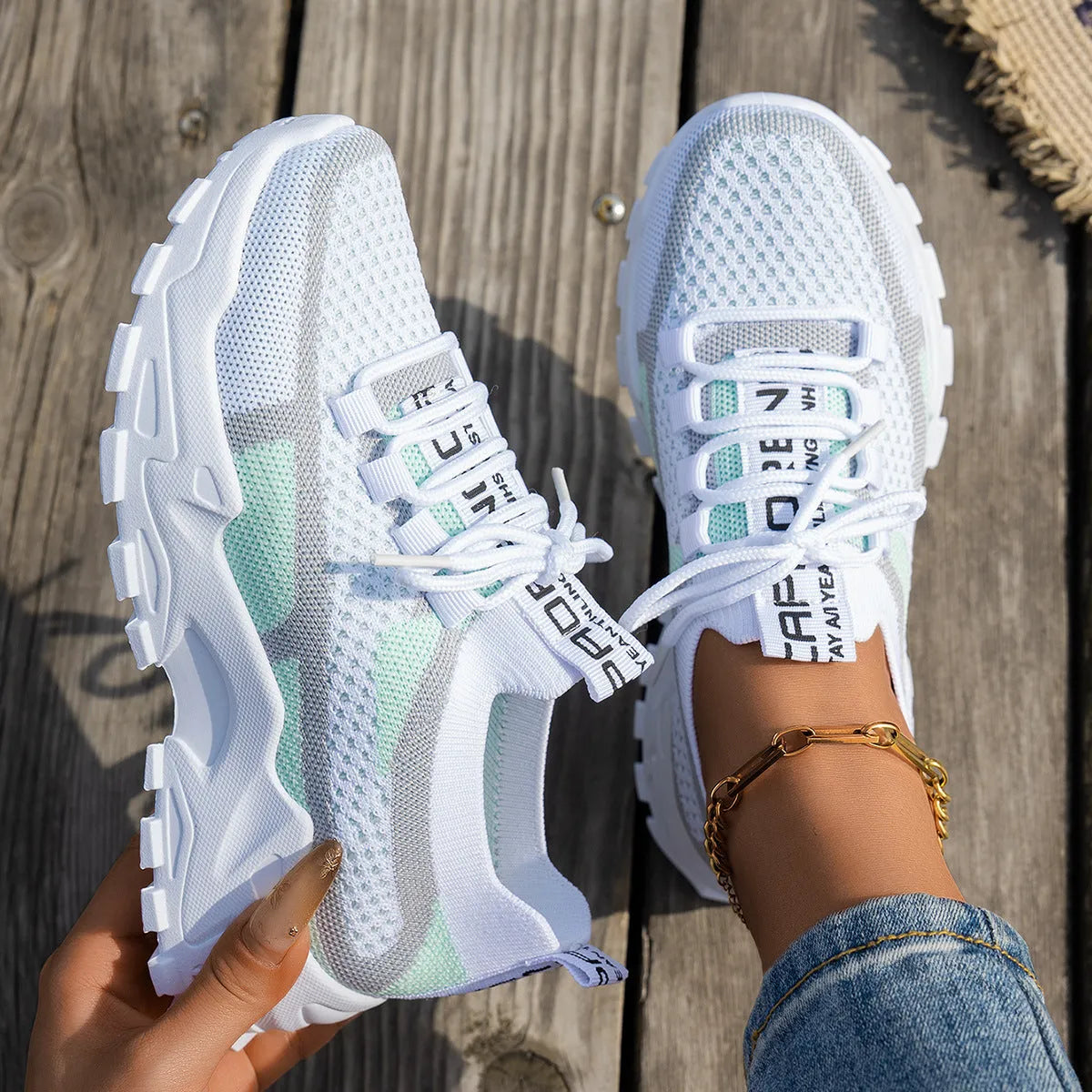 Women's Flyknit mesh lace-up sneakers in grey and white with a low rubber sole.