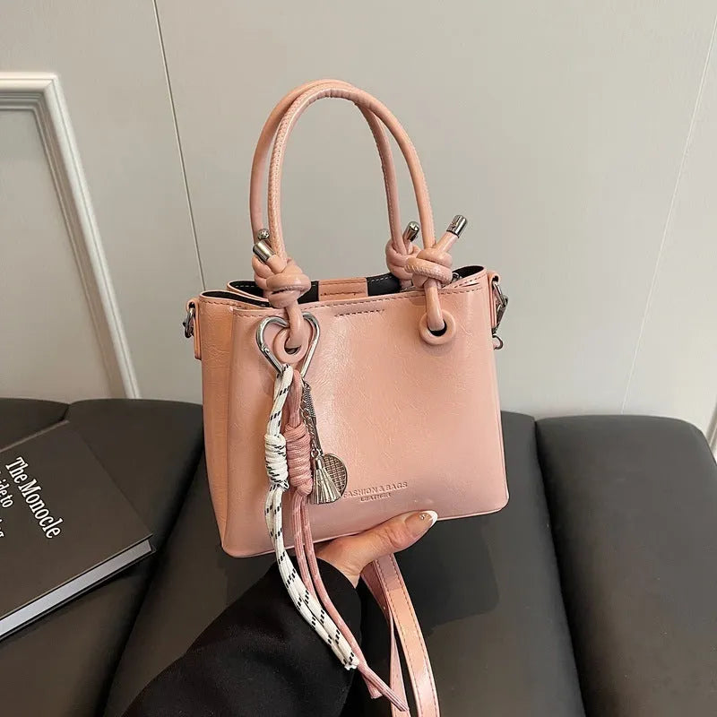 Women's medium-soft PU messenger bag in bucket shape with pendant, black, white, wine red, and pink options
