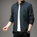 Man wearing a loose-fit black casual autumn jacket with a lapel and zippered pockets.