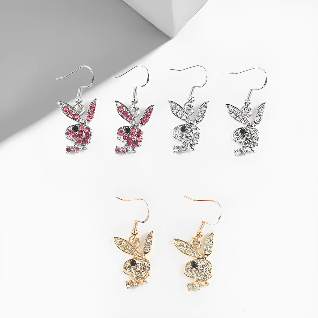 Close-up of rabbit-shaped stud earrings with sparkling cubic zirconia stones in gold, pink, and silver finishes.