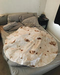 Round coral coloured flannel burrito blanket with a delicious print, shown folded.