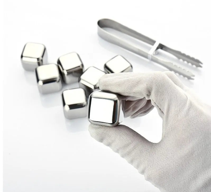 Set of eight stainless steel whiskey chilling stones and metal clip in storage box.