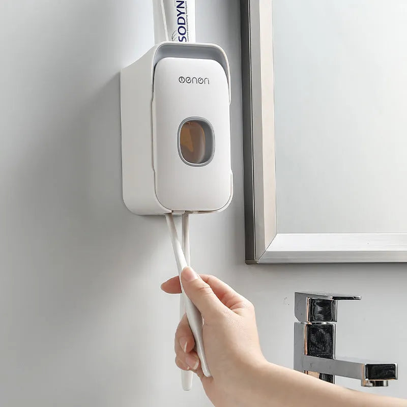 Blue automatic toothpaste dispenser made of ABS plastic mounted on a bathroom wall.