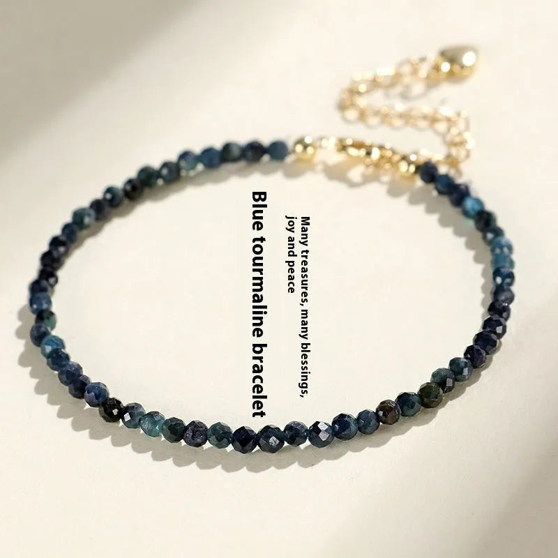 Blue tourmaline gemstone bracelet with 3mm cut beads on a white background.