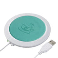 USB-powered insulated heating coaster in black, blue, and orange colours on a desk.