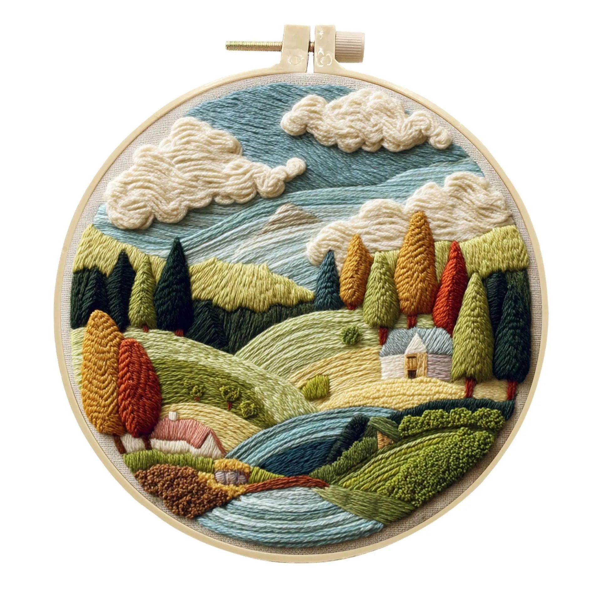 Embroidery DIY kit components: printed landscape fabric, embroidery hoop, coloured threads, and needles laid flat.