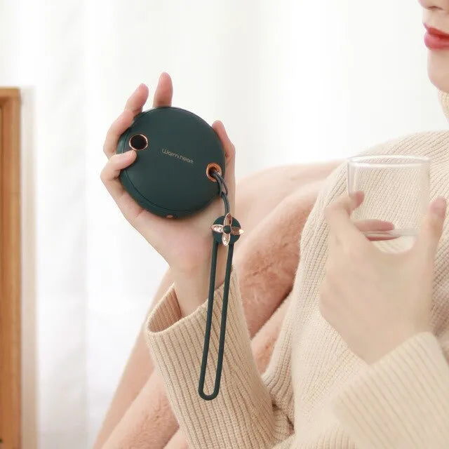 Green square hand warmer power bank with digital display showing charge level, next to a charging cable.