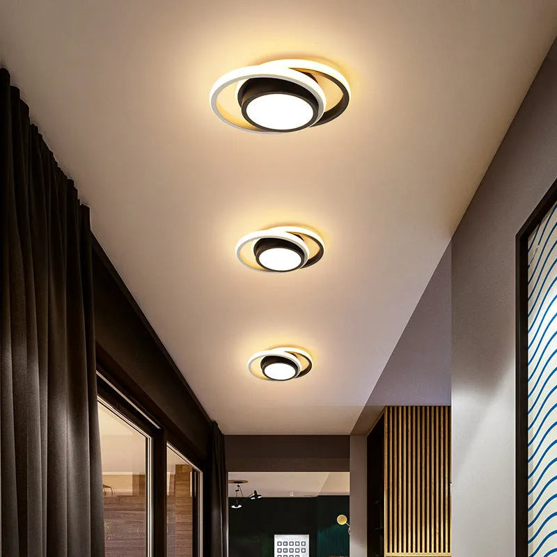 Modern round aluminium ceiling light with integrated LEDs, shown illuminating an entrance hall.
