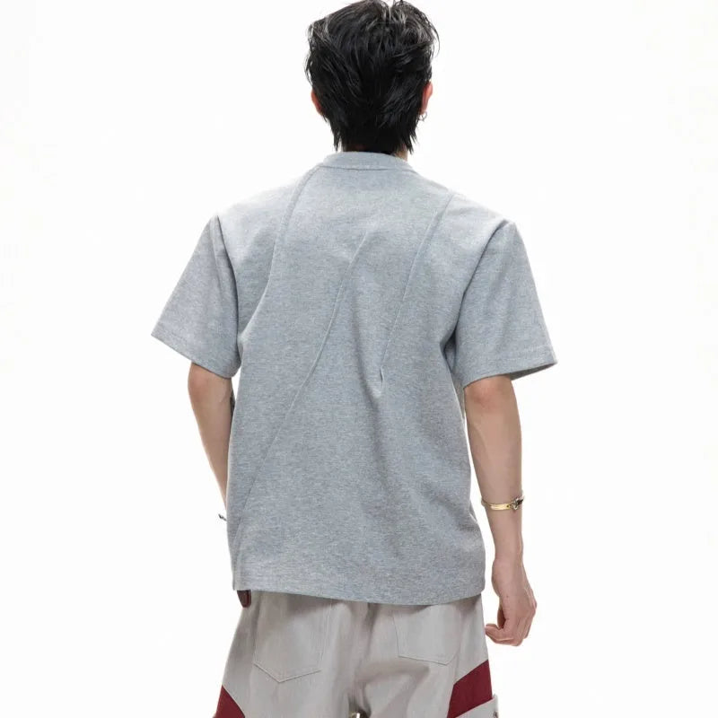 Men's grey pleated cotton t-shirt with round neck and short sleeves on a loose fit model