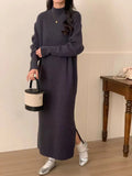 Woman wearing a milky white half turtleneck long sleeve knitted midi dress with a high waist.