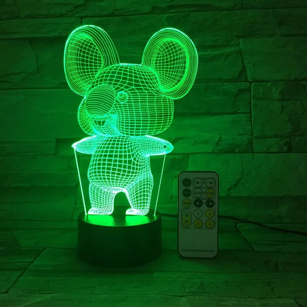 Black koala-shaped LED night light with remote control on a table.