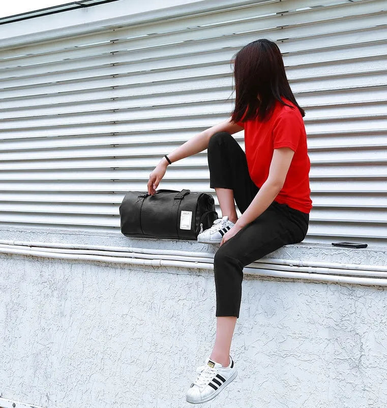 Black waterproof sports duffle bag with a separate side shoe compartment and diagonal shoulder straps.