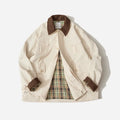 Casual apricot and green polyester jacket with side seam pockets on a hanger.