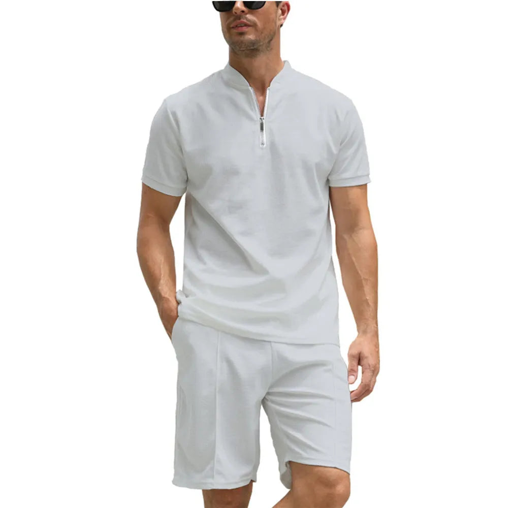 Men's solid colour polo shirt and trouser two-piece set in textured fabric.