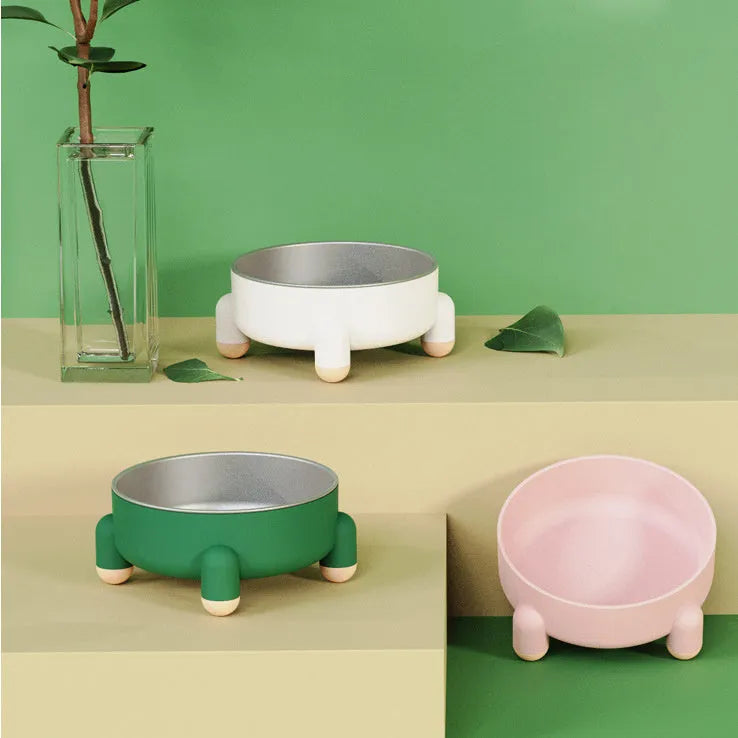 Green non-slip stainless steel pet bowl with high foot base on a floor.