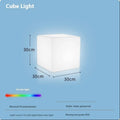 Modern square LED cube light stool in a garden setting, showcasing its clean design and luminous top.